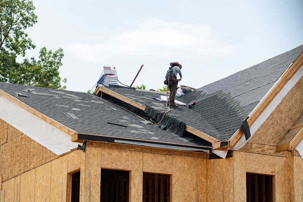 Close view of damaged roof valley shingles with exposed flashing and water stains on the decking.