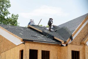 Close view of damaged roof valley shingles with exposed flashing and water stains on the decking.